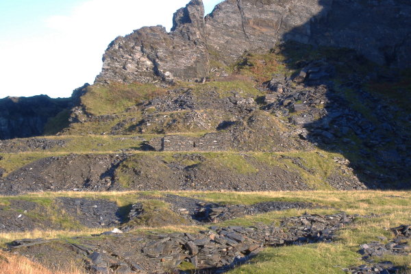 photograph looking inland at all the piles of slate spoil, the artificial terraces, the buildings.