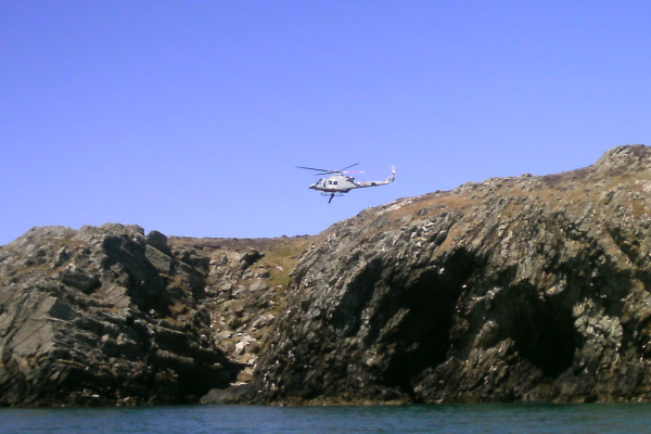 photograph of helicopter with winchman on the wire 