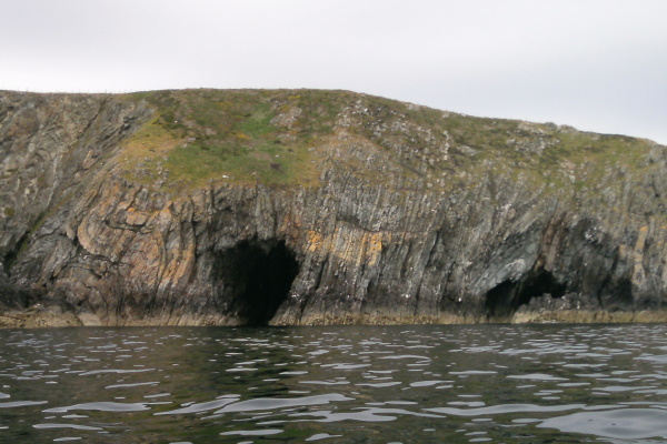 photograph of the coastline loking at two caves. 