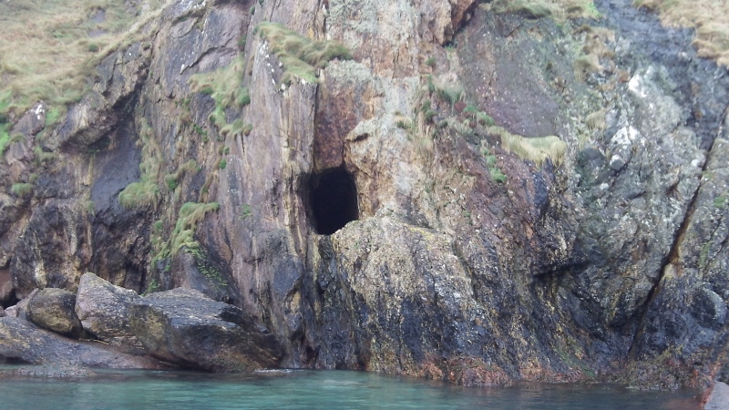 the entrance to a mine in the rock face, just above the sea 