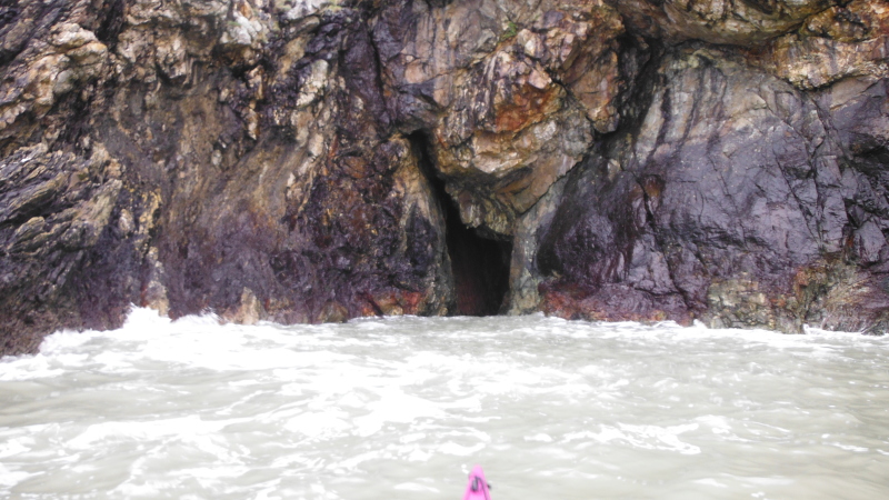 entrance to the cave, with purple rocks on either side 