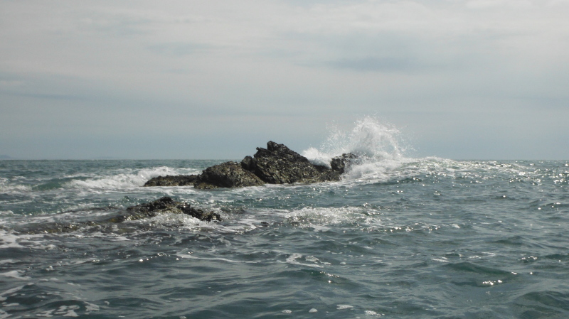  the swell breaking over the rock  