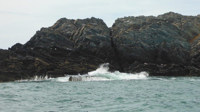  the swell breaking over a rock slab  