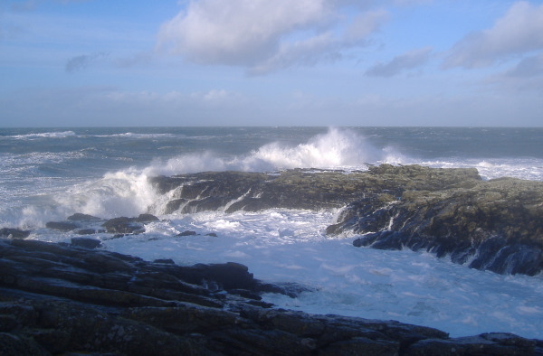 photograph of waves breaking on the point at Cemlyn