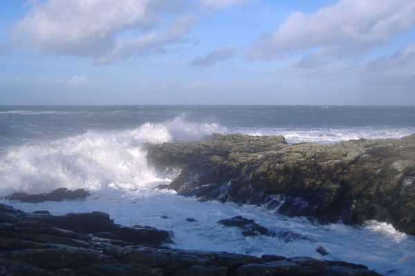 photograph of waves breaking on the point at Cemlyn