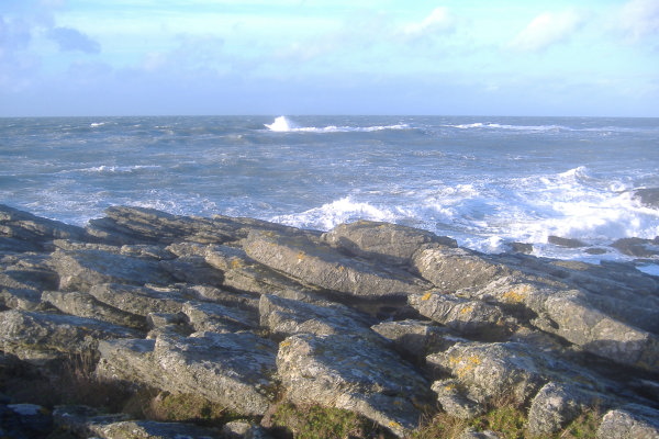 photograph of a big  wave breaking over the Harry Furlough`s Rocks