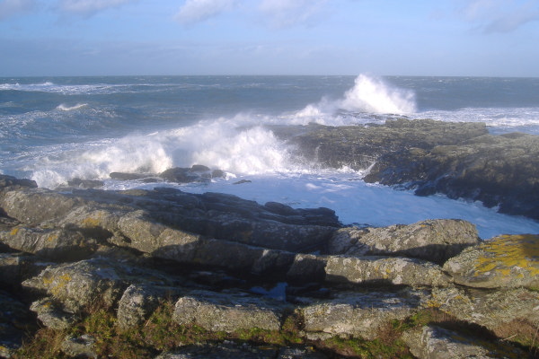 photograph of waves breaking on the point at Cemlyn