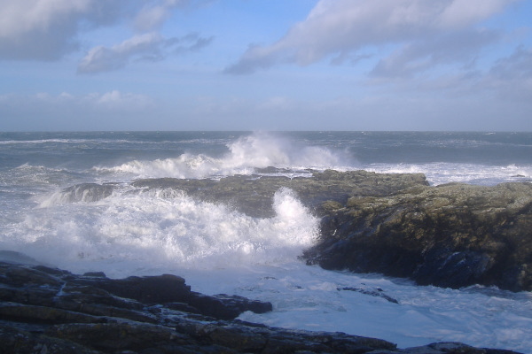 photograph of waves breaking on the point at Cemlyn