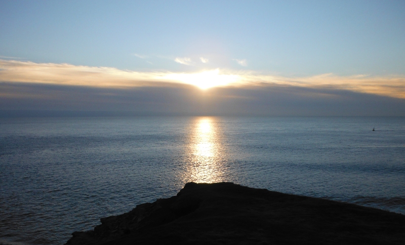  the sun setting behind a large bank of cloud 