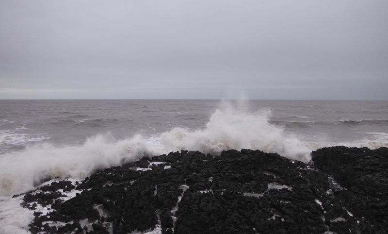  the waves breaking over the rocks 