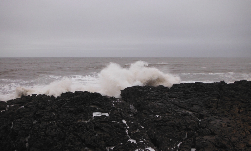  the waves breaking over the rocks 