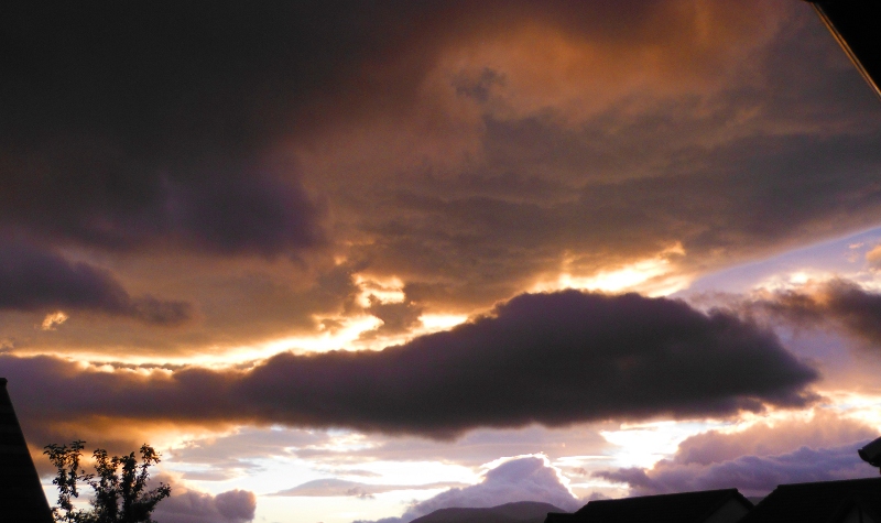  the setting sun lighting up the underneath of the clouds 