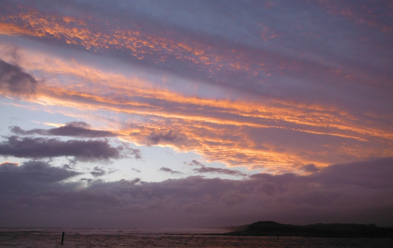  the sunset appearing through a hole in the clouds 