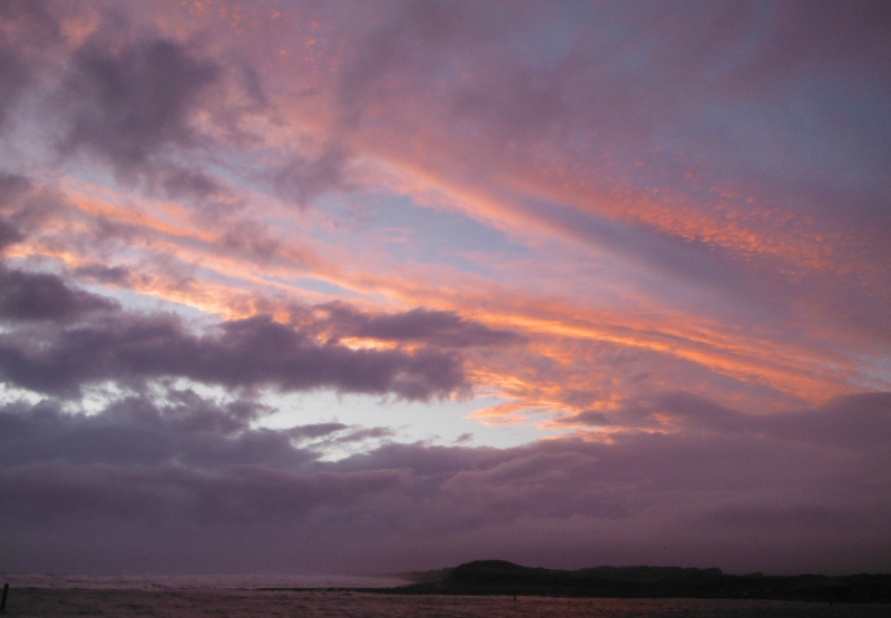  the sunset appearing through a hole in the clouds 