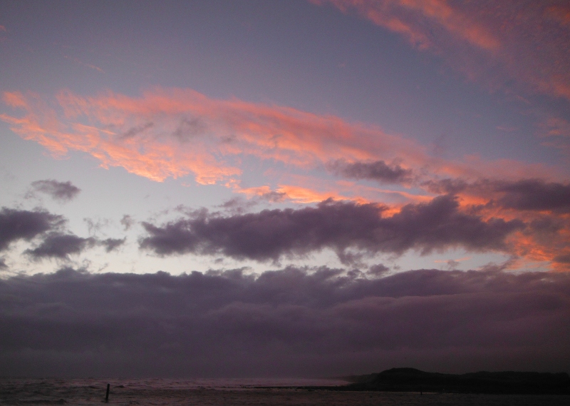  the sunset appearing through a hole in the clouds 