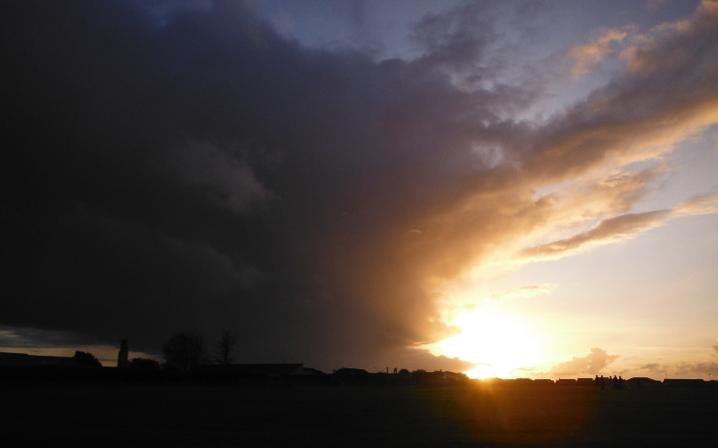  the sunset disappearing behind the rain cloud 